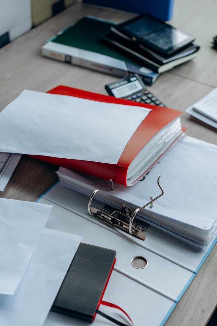 Tidy office desk with binders, papers, and stationery, ideal for business or education themes.